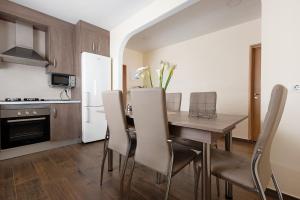 una cucina e una sala da pranzo con tavolo e sedie in legno di Casa Margarita a La Guancha