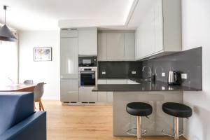 a kitchen with white cabinets and black counter tops at Treviso City Town 3 in Treviso