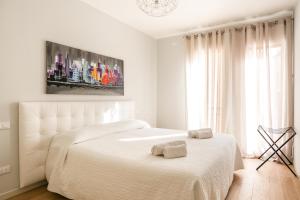 a white bedroom with a bed with two towels on it at Treviso City Town 3 in Treviso
