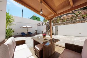 une terrasse avec une table, des chaises et un parasol dans l'établissement Casa Margarita, à La Guancha