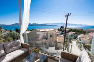 a balcony with a couch and a view of the water at Kalipso & Nafsika Maisonettes Grey Diamond in Nikiana