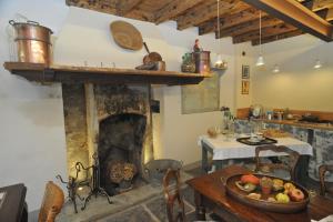 a kitchen with a fireplace and a table with a plate of food at Casa Lumaca in Tremezzo