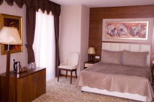 a bedroom with a bed and a table and a chair at Kerimbey Hotel in Gemlik