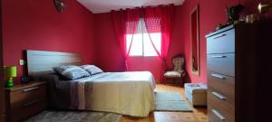1 dormitorio con paredes rojas, 1 cama y ventana en Villa Blas - Camiño Portugués-, en Redondela