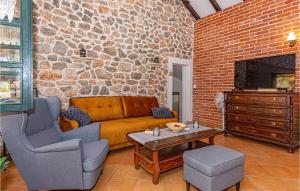a living room with a couch and a stone wall at Stunning Home In Vodice With 2 Bedrooms, Wifi And Outdoor Swimming Pool in Vodice