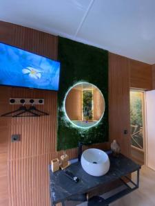 een badkamer met een ronde spiegel en een wastafel bij Esprit BALI ....LOVE SPA, Sauna de luxe à Mulhouse in Mulhouse