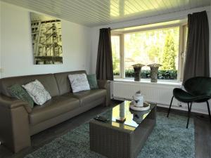 a living room with a couch and a table at Chalet nr 10 op Bospark Trimunt in Marum