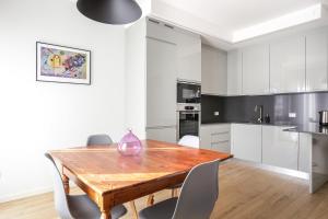a kitchen with a wooden table and white cabinets at Treviso City Town 3 in Treviso +5 photos