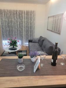 a living room with a couch and a table with wine glasses at TILA 2 in Trebinje +8 photos