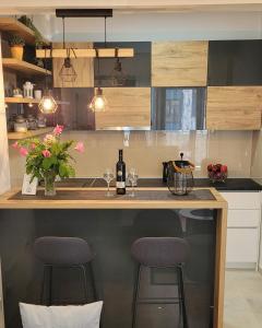 a kitchen with a counter with two stools at a bar at TILA 2 in Trebinje