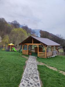 a wooden gazebo in a park with a playground at Casa Alesi in Dragoslavele