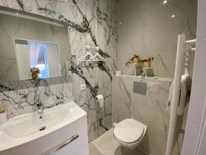 łazienka z umywalką, toaletą i lustrem w obiekcie Esprit MALDIVES ...... SPA LOVE au coeur de Mulhouse w Miluzie