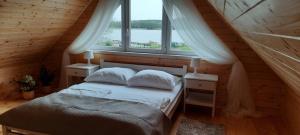 Dormitorio con cama y ventana en una cabaña en Szary domek nad jeziorem, en Kołczewo