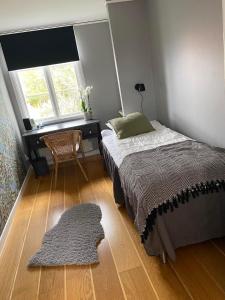 een slaapkamer met een bed, een bureau en een tapijt bij Villa Löfström in Timmernabben