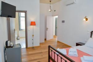 a bedroom with a bed and a television in a room at Mansion Dasi in Spetses