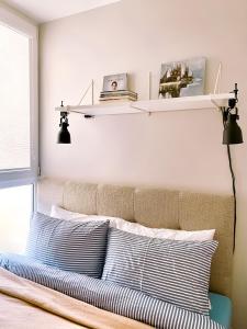 a bedroom with a bed with two pillows and shelves at Laiminga Smilga in Juodkrantė