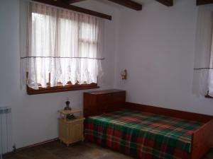 ВИЛА ПЕРИКА-Vila PERIKA في Borino: غرفة نوم صغيرة بها سرير ونافذة