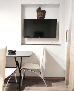 ein Wohnzimmer mit einem Tisch und einem TV an der Wand in der Unterkunft Tanners' Bridge Apartments in Tirana