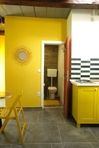 a bathroom with a toilet and a yellow wall at Balkan Retreat in Bešenovo