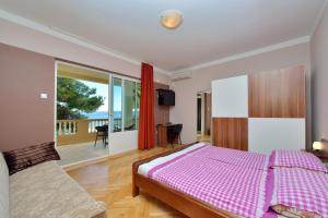 ein Schlafzimmer mit einem Bett und einem Balkon in der Unterkunft Guest House Malenica in Sukošan