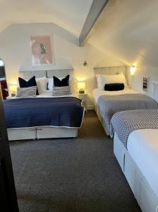 a bedroom with two beds with blue and white sheets at The Dozy Deer in Windermere