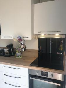 a kitchen with white cabinets and a microwave at citesteloi in Friville-Escarbotin