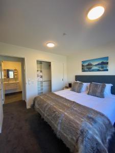 Un dormitorio con una cama grande con una manta. en Luckie Lane Homestay en Queenstown