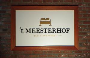 
a sign on the side of a brick building at B&B 't Meesterhof in Deinze
