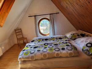 a bed with a comforter and a window in a room at Pension Family in Karlovy Vary