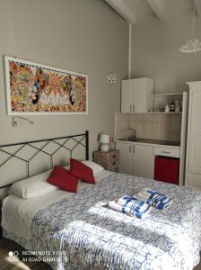 Schlafzimmer mit einem Bett mit roten und blauen Kissen in der Unterkunft Case Vacanza Le Casette in Santo Stefano di Camastra