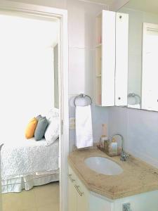 baño con lavabo y cama en Apt em condomínio de luxo à beira mar de Jatiúca, en Maceió