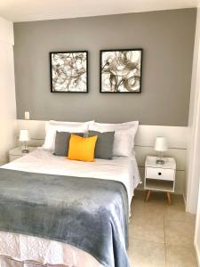 1 dormitorio con 1 cama con 2 cuadros en la pared en Apt em condomínio de luxo à beira mar de Jatiúca, en Maceió