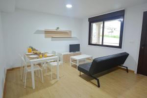 sala de estar con mesa y silla en Apartamentos Playa Area Grande, en San Vicente de O Grove