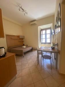 een woonkamer met een tafel en een bed bij Monolocale in Via Poerio in Catanzaro
