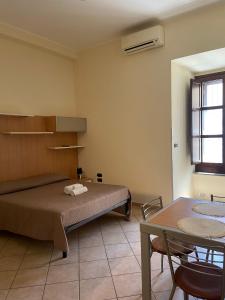 een slaapkamer met een bed en een tafel en een tafel bij Monolocale in Via Poerio in Catanzaro