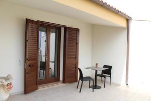 a patio with a table and chairs and a door at B&B San Vito in Tricase