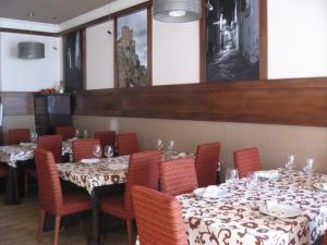 un comedor con mesas y sillas con platos y copas de vino en Hotel Machaco, en Alburquerque