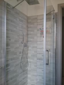 a shower with a glass door in a bathroom at B&B da Rosella in Lotzorai