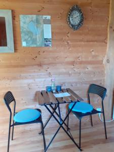ein Tisch mit zwei Stühlen und eine Uhr an der Wand in der Unterkunft Knutstorp Ranch in Tyringe + 11 Fotos