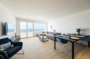 a living room with a table and a couch at Apartment 2 bedrooms with magnificent seaview and free parking in Ostend