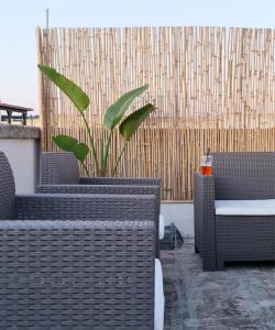 a patio with wicker chairs and a potted plant at GAYA MARINA in Lido Marini