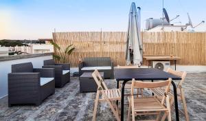a patio with a table and chairs and an umbrella at GAYA MARINA in Lido Marini +8 photos
