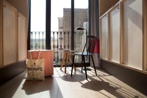 a room with a balcony with a table and chairs at TOC Hostel Barcelona in Barcelona