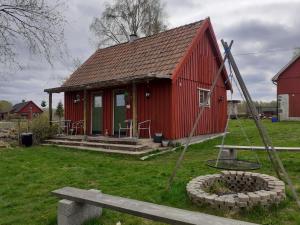 une maison rouge avec un banc devant elle dans l'établissement Knutstorp Ranch, à Tyringe