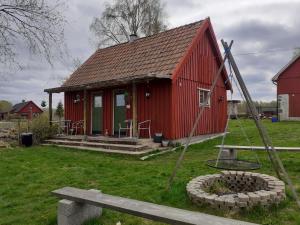 ein rotes Haus mit einer Bank davor in der Unterkunft Knutstorp Ranch in Tyringe