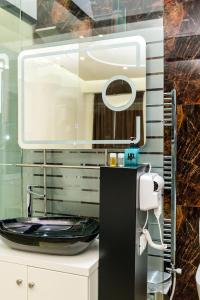 a bathroom with a black sink and a mirror at Hotel Pazari & Apartments in Korçë