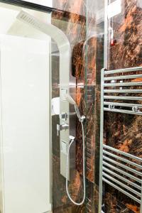 a shower in a bathroom with a glass wall at Hotel Pazari & Apartments in Korçë