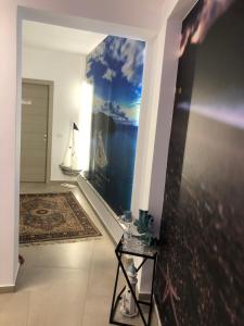 a hallway with a painting of a sailboat on the wall at DonnaRosaHOME in Oliveri