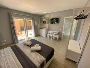 Cet appartement comprend une chambre avec un lit, une cuisine et une table. dans l'établissement Cantinho do Sol (Estúdio Prata), à Lourinhã
