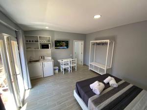 a bedroom with a bed and a kitchen with a table at Cantinho do Sol (Estúdio Prata) in Lourinhã